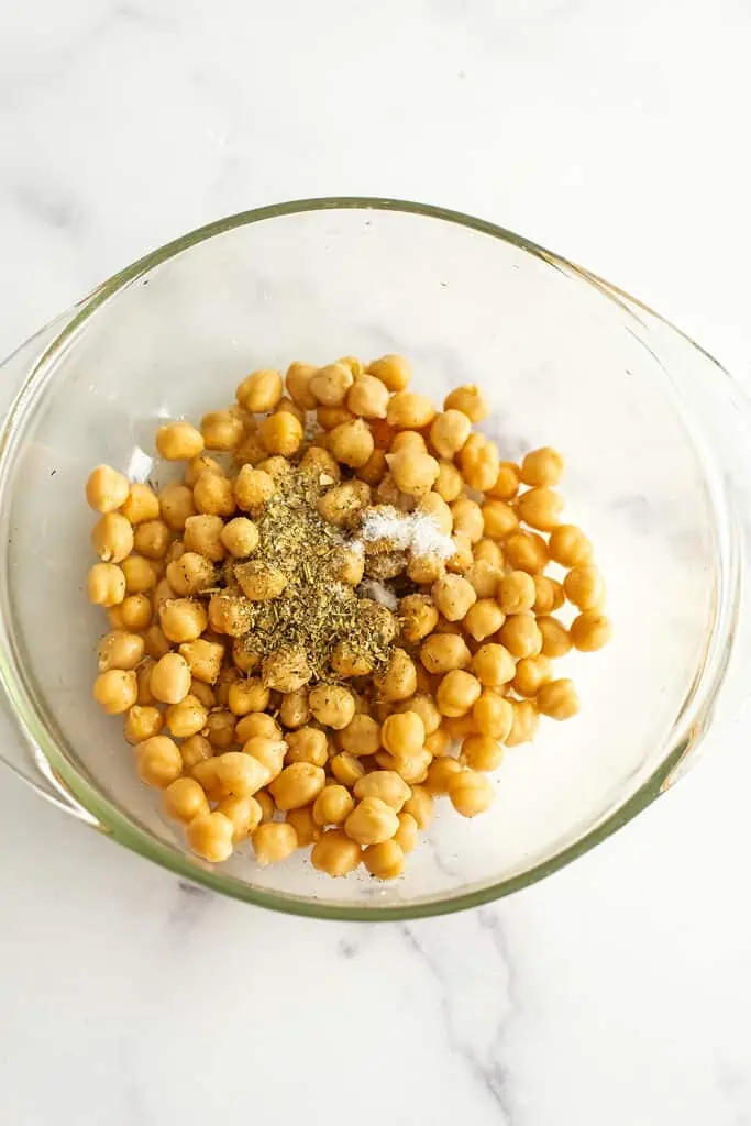 Chickpeas in a bowl with spices on top.