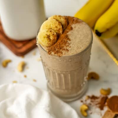 Banana cinnamon smoothie topped with sliced bananas and cinnamon.