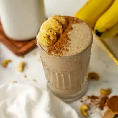 Banana cinnamon smoothie topped with sliced bananas and cinnamon.