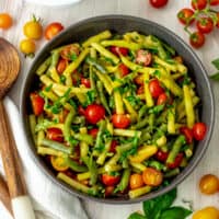 Italian green bean salad in a gray bowl on a white table.