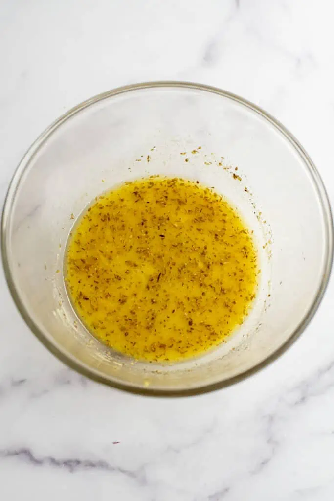 Lemon vinaigrette ingredients in a large bowl after being stirred well.