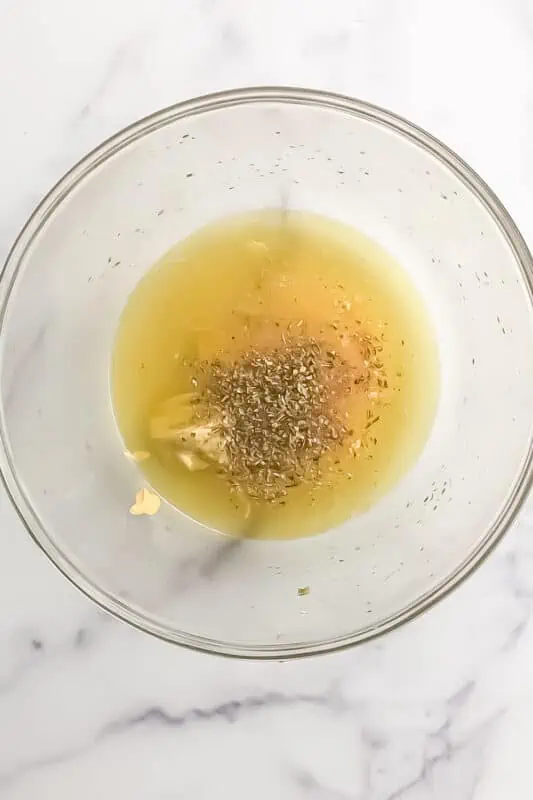Lemon vinaigrette ingredients in a large bowl before stirring.