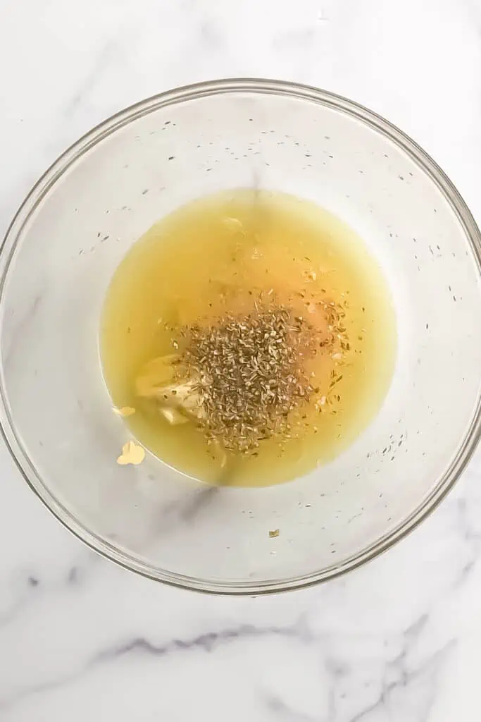 Lemon vinaigrette ingredients in a large bowl before stirring.