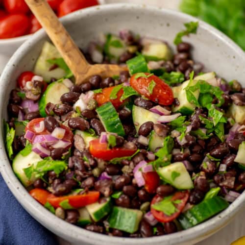 Mediterranean black bean salad in a white bowl.