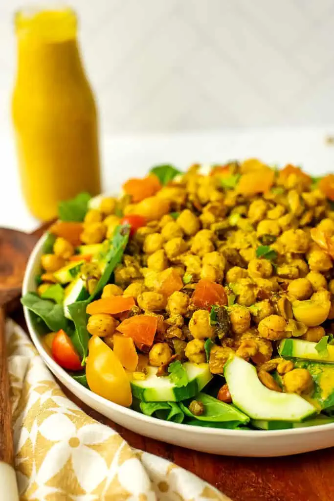 Spinach chickpea salad next to a bottle of turmeric dressing.