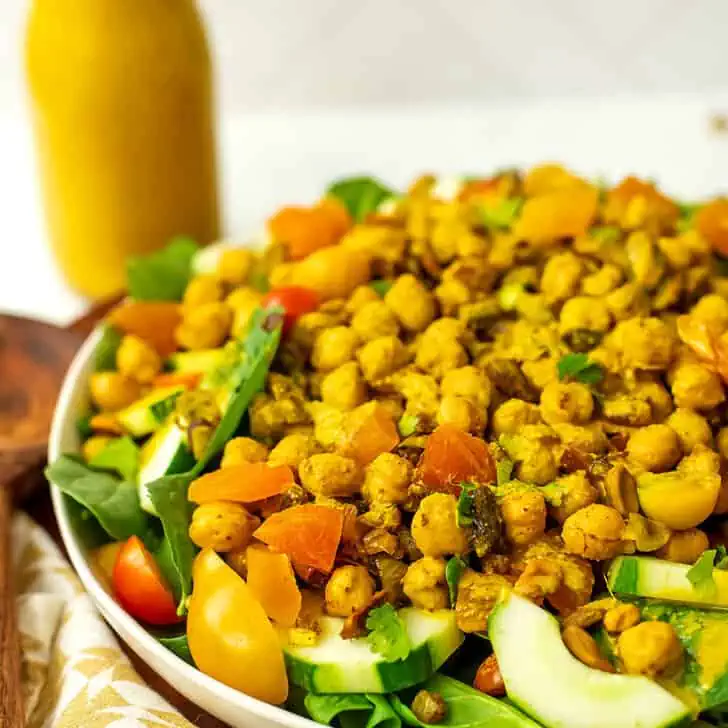 Spinach chickpea salad next to a bottle of turmeric dressing.