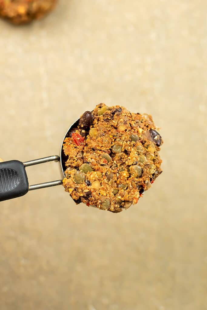 Measuring cup filled with lentil black bean burger mixture.