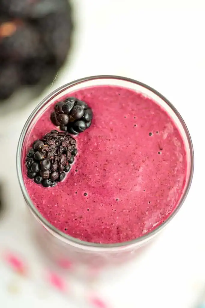 blackberry oatmeal smoothie with two blackberries garnishing the top.