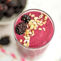 Blackberry oatmeal smoothie garnished with granola on top.