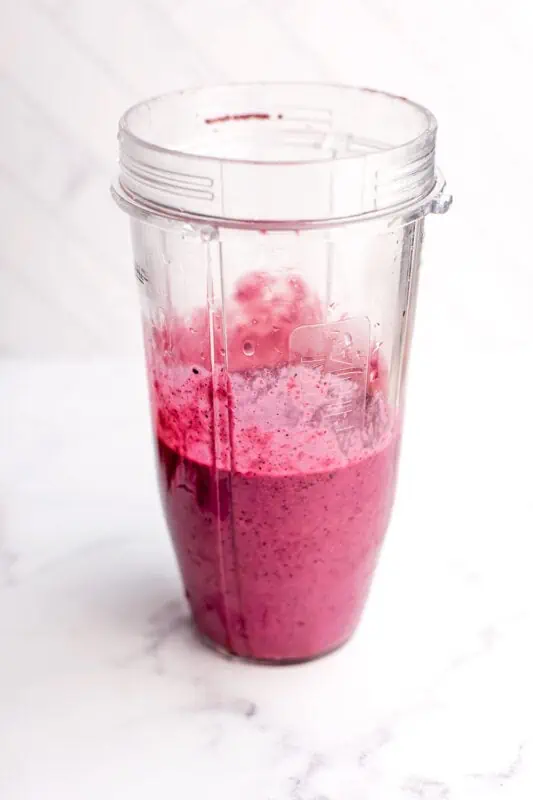 Blueberry raspberry smoothie in a blender cup after being blended.