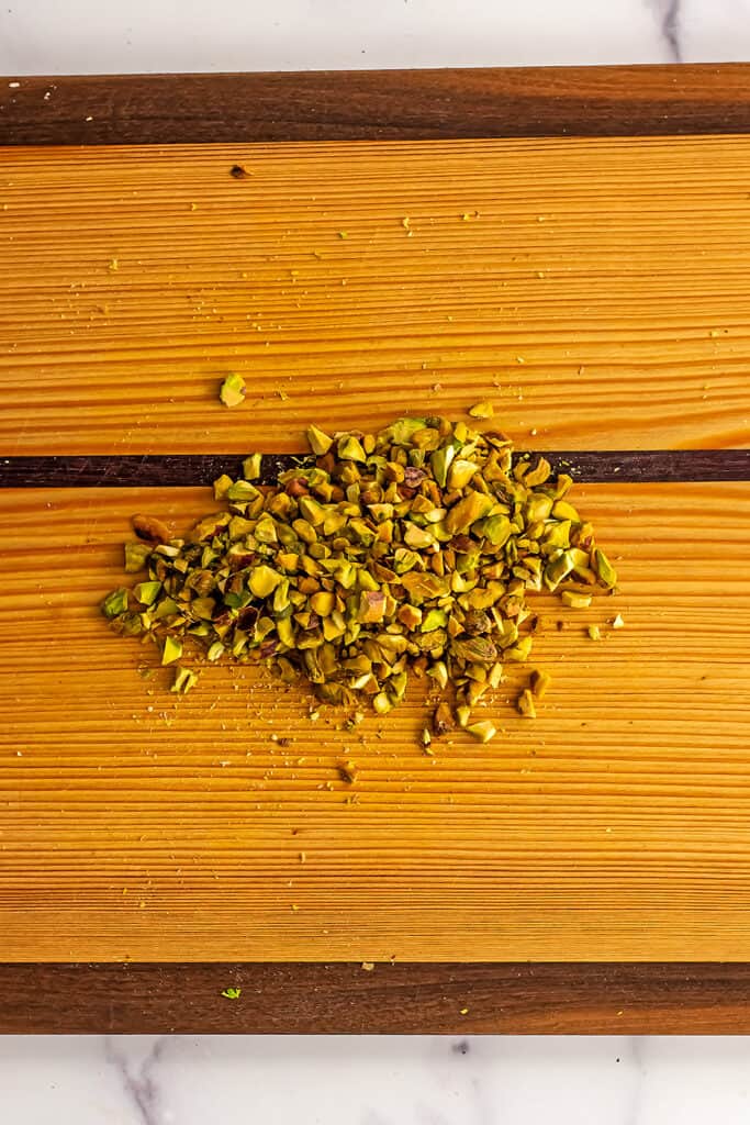 Chopped pistachios on a cutting board.