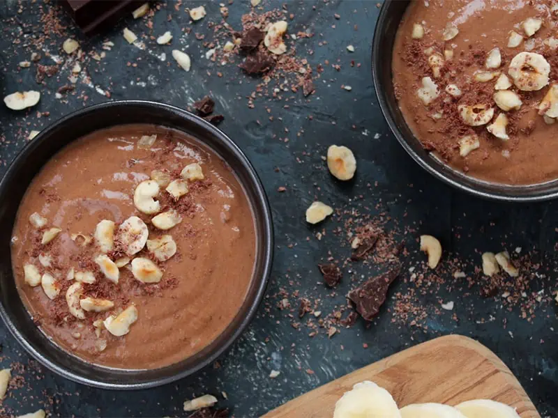 Dark chocolate protein smoothie bowls with macadamia nuts on top