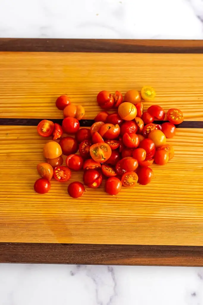 Cherry tomatoes on a wooden cutting board.