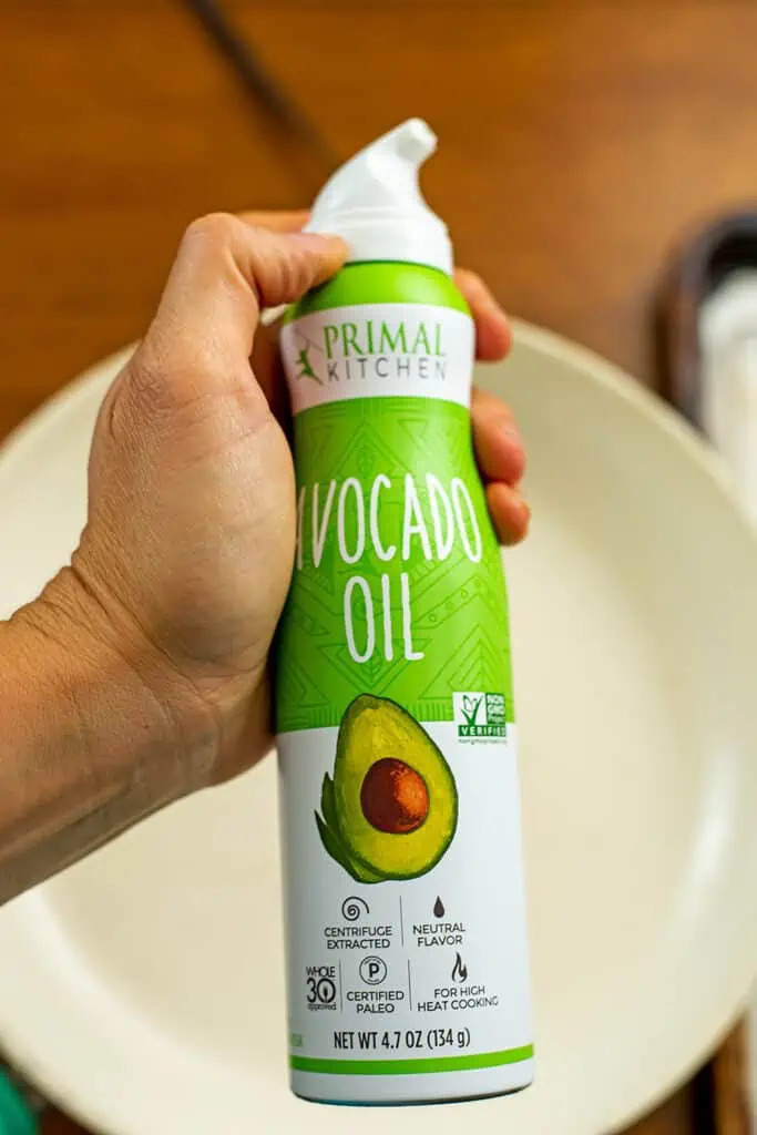 Hand holding a can of avocado oil.