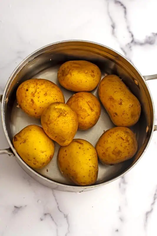 Gold potatoes in water in a large pot.