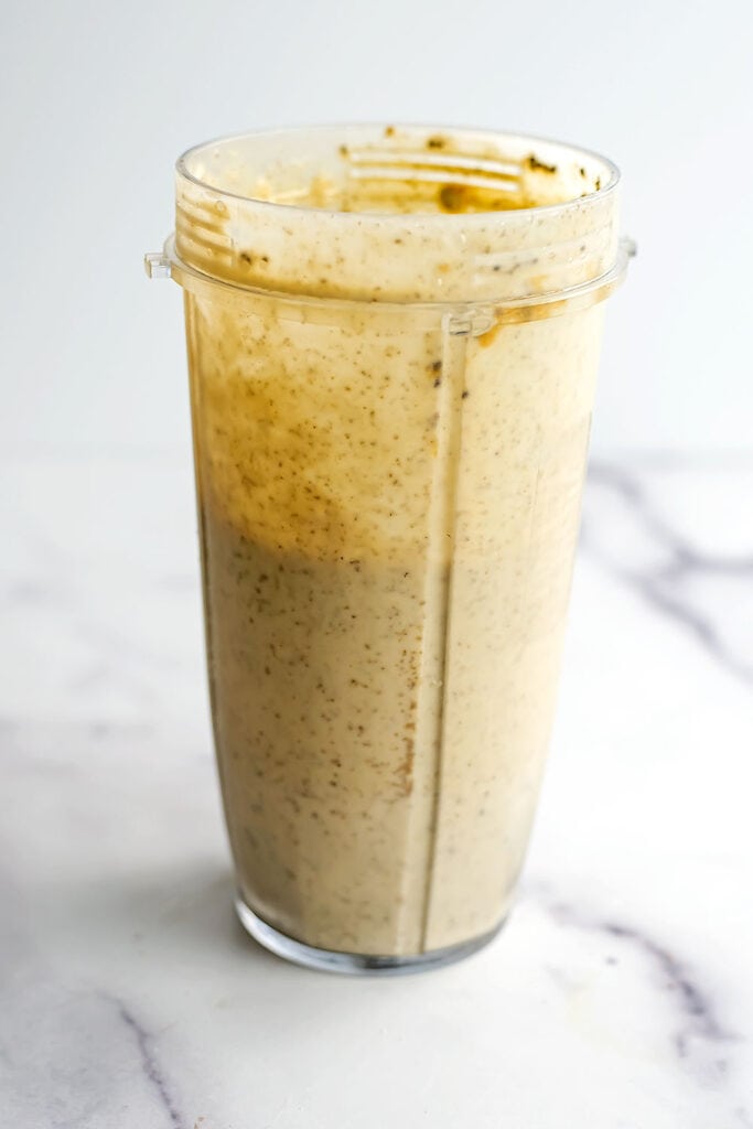 Banana peach smoothie bowl in a blender cup after being blended.