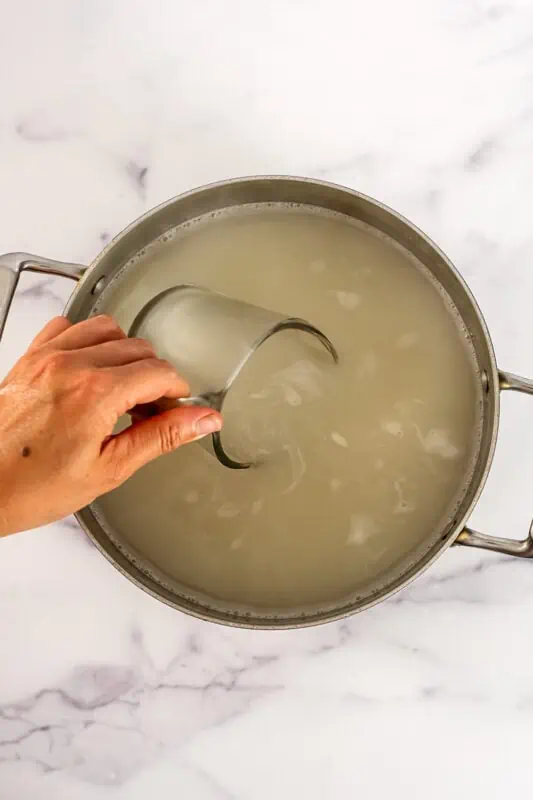 Measuring cup in pasta water.