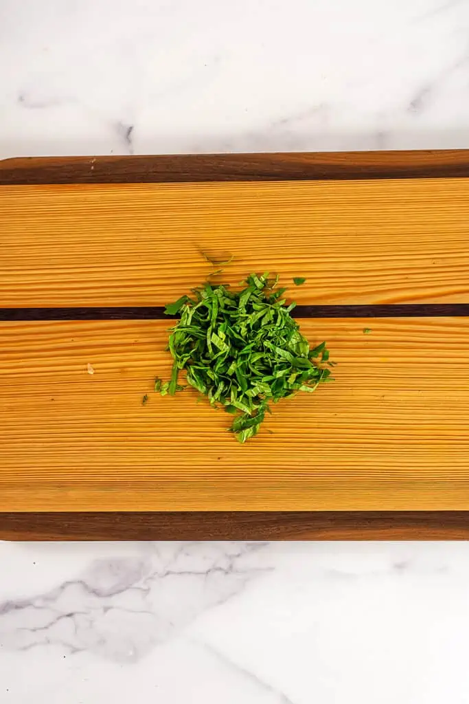 Finely chopped fresh basil on a cutting board.