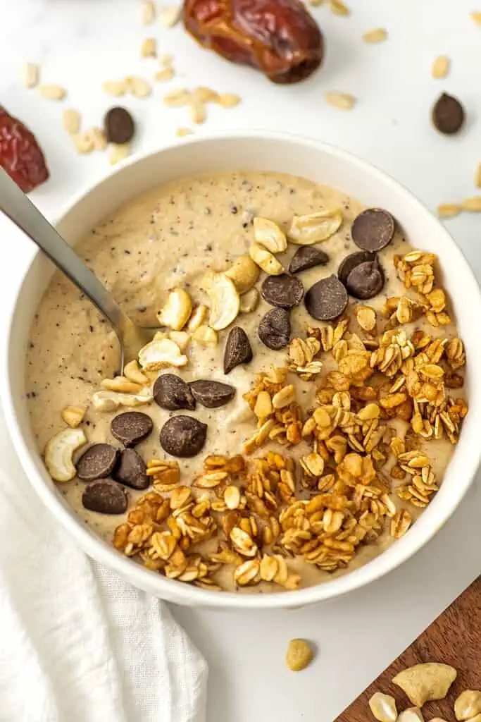 Cookie dough smoothie bowl with cashews, chocolate chips and granola as toppings.