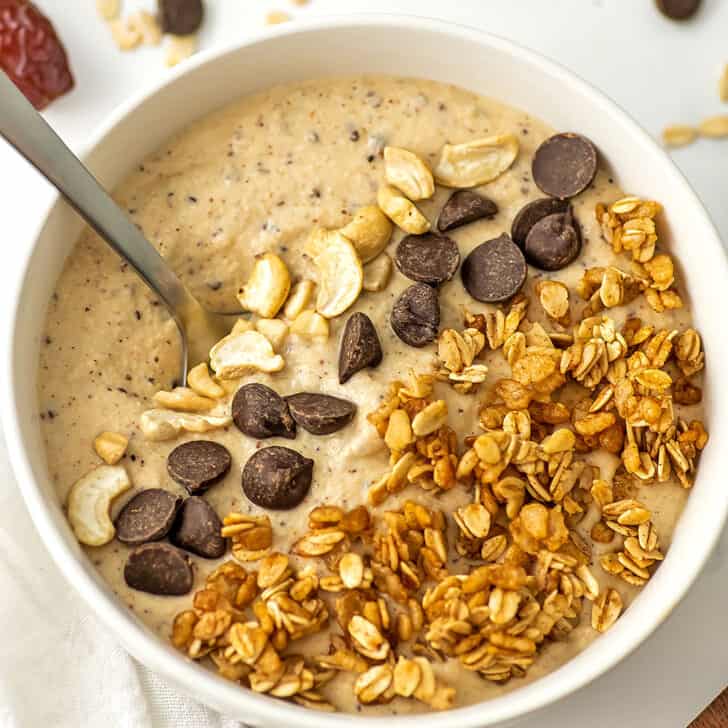 Cookie dough smoothie bowl with cashews, chocolate chips and granola as toppings.
