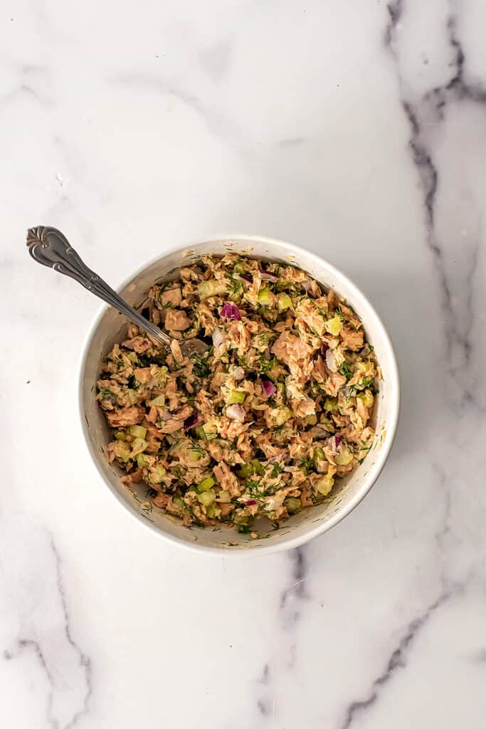 Dill tuna salad in a bowl with spoon on the side.