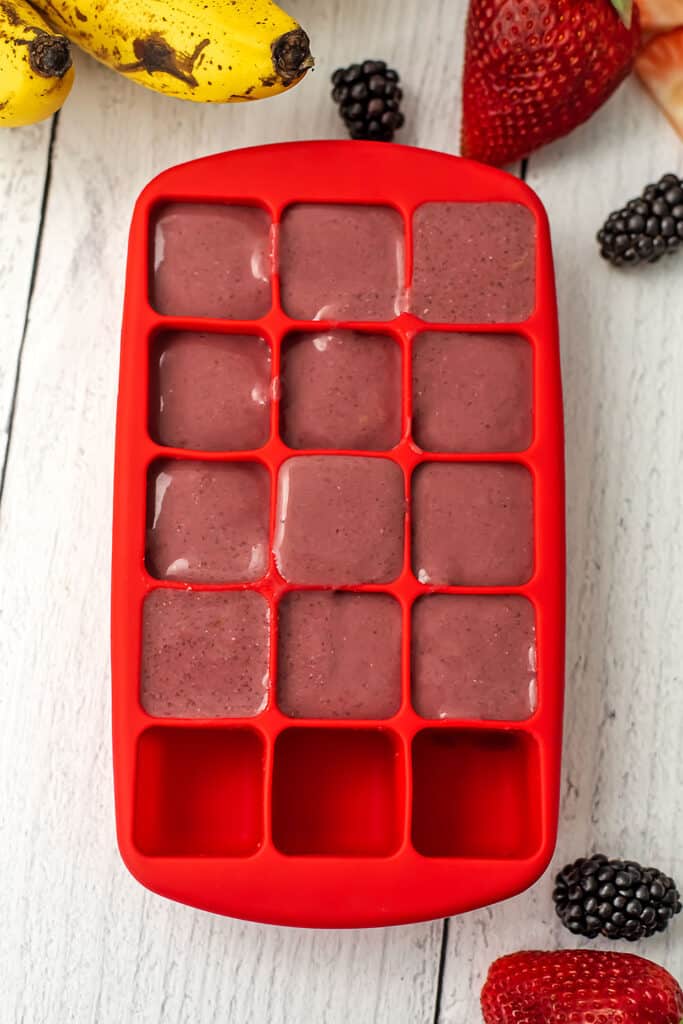 A silicon ice cube tray with smoothie in it to be frozen for later.