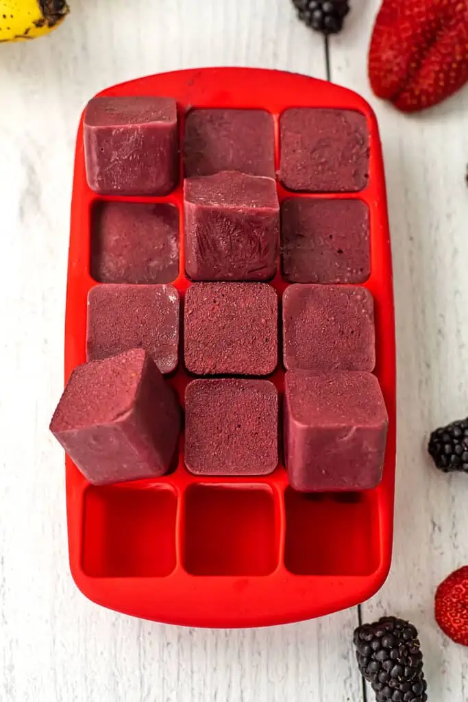 A silicon ice cube tray with frozen smoothie cubes. Pre make smoothie in an ice cube tray and freezing for later.