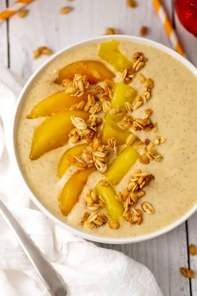 Peach pineapple smoothie bowl with peaches, pineapple and granola on top.