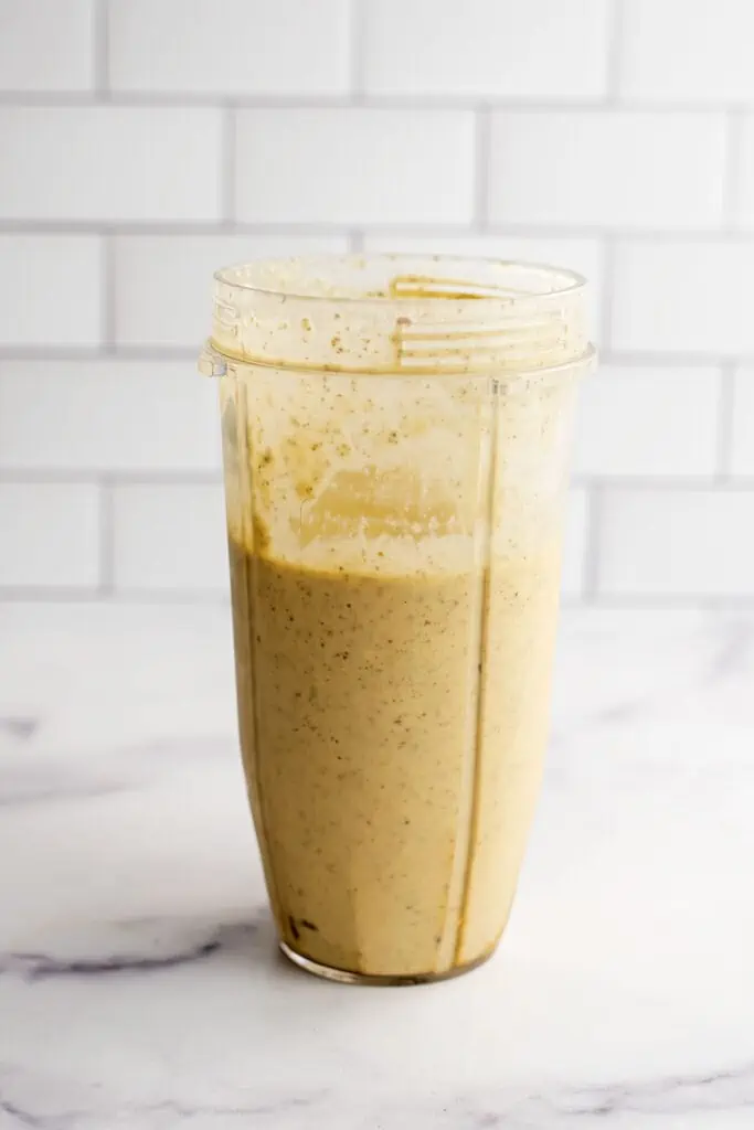 Peach pineapple smoothie recipe in a blender cup after being blended.