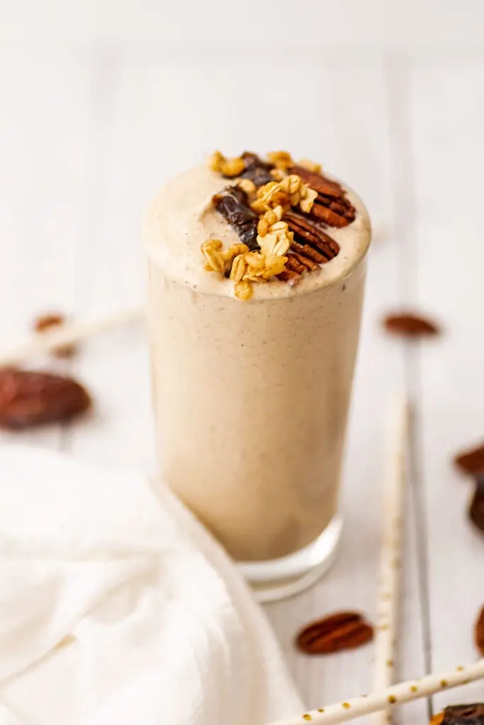 Pecan pie smoothie with pecans, dates, and granola on top.
