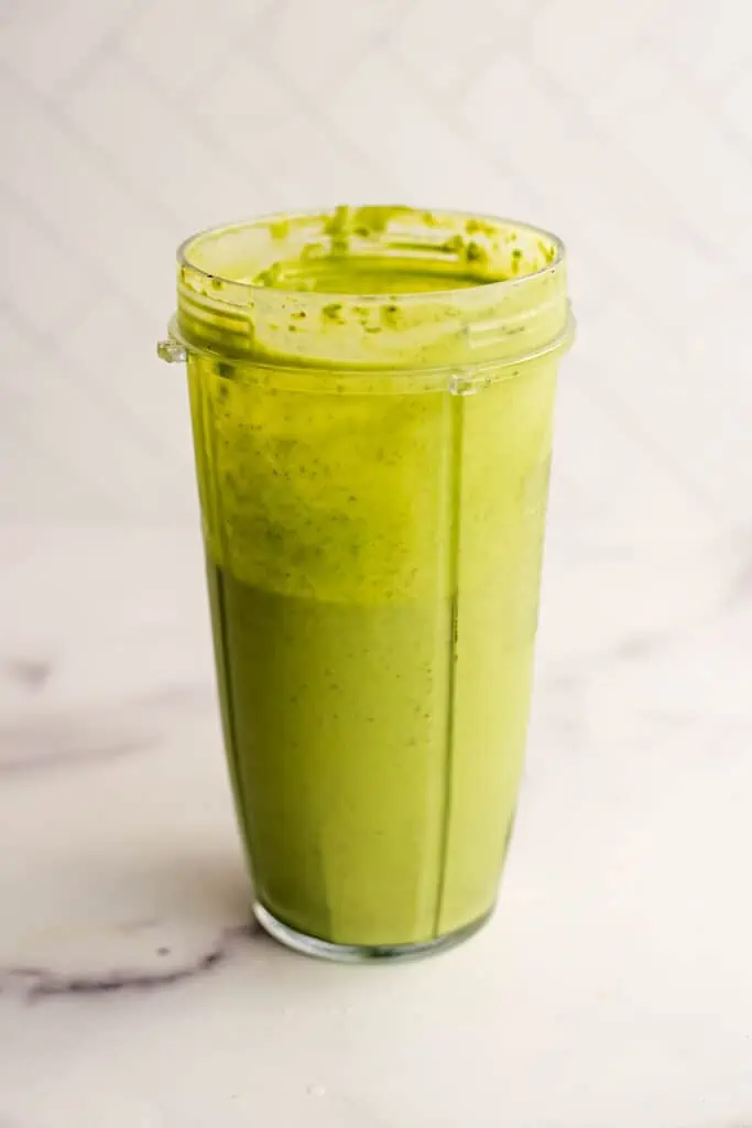 Pineapple matcha smoothie in a blender cup after blending.