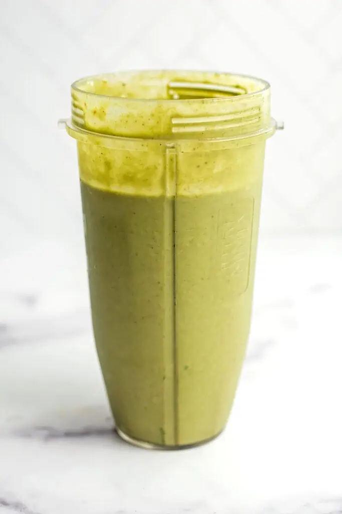 Strawberry banana spinach smoothie in  blender cup after being blended.