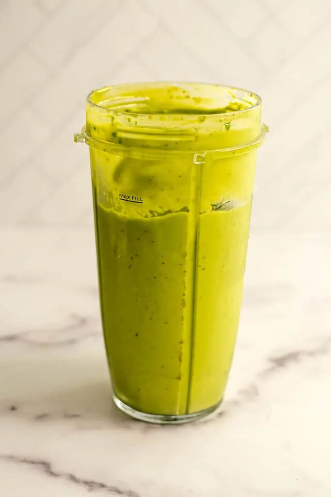 Avocado date smoothie in a blender cup after being blended.