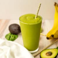 Avocado date smoothie with a straw.