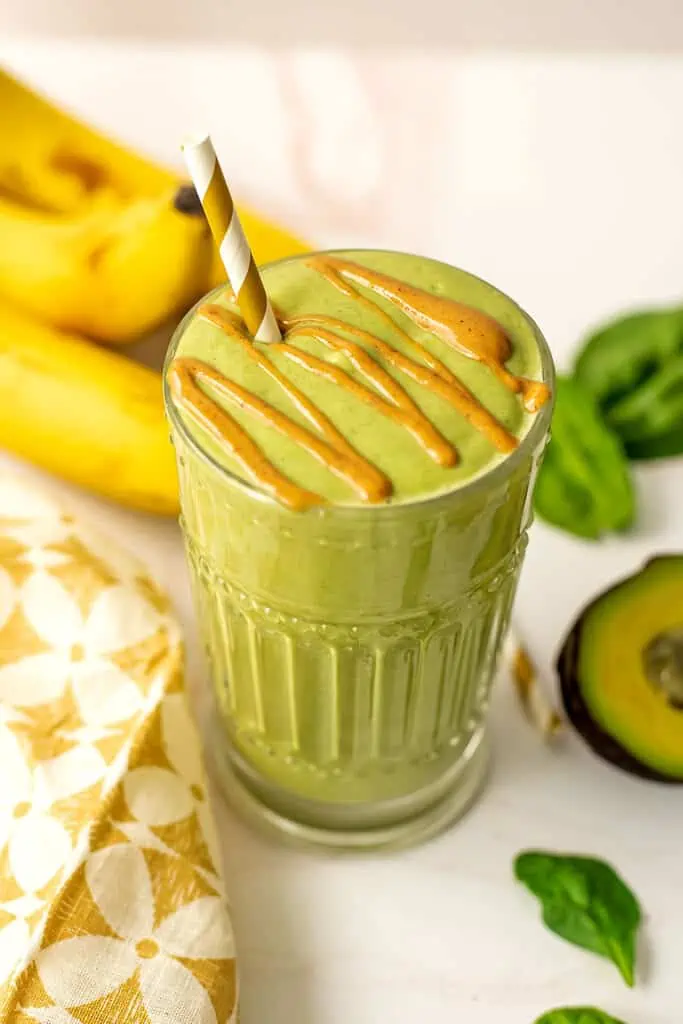Banana avocado peanut butter smoothie with peanut butter drizzle on top.