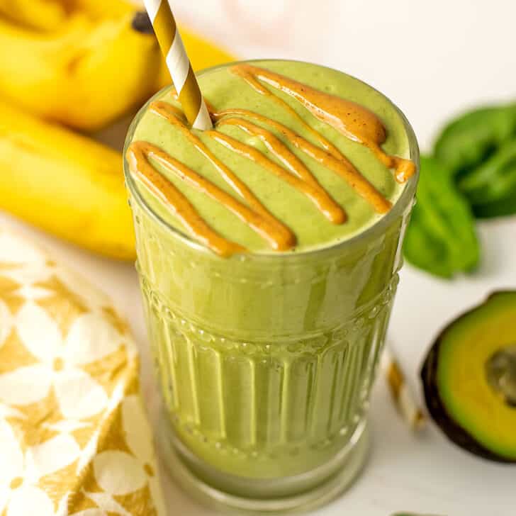 Banana avocado peanut butter smoothie with peanut butter drizzle on top.