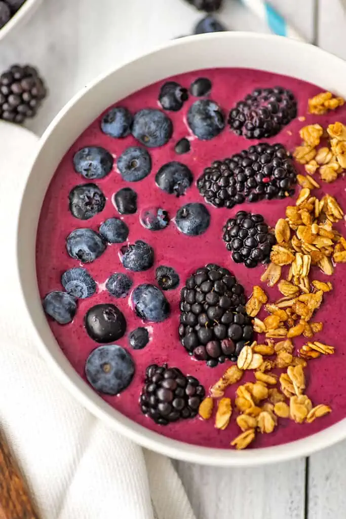 Blueberry blackberry smoothie bowl with blackberries, blueberries and granola on top.