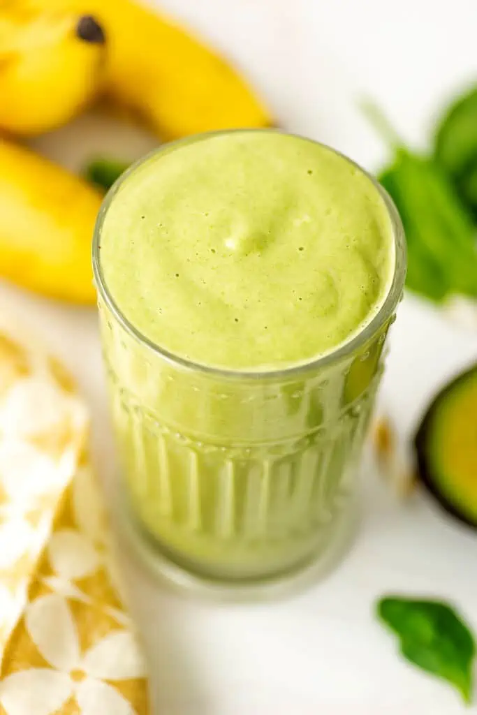 Peanut butter banana avocado smoothie in a short glass.