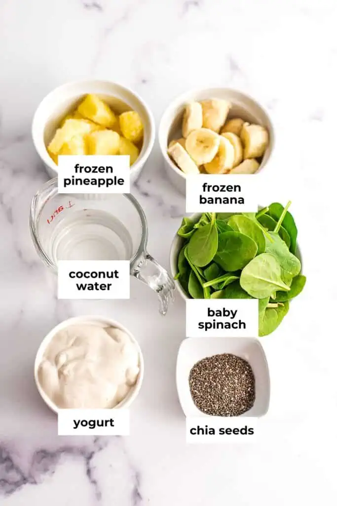 Pineapple banana spinach smoothie ingredients in white ramekins.