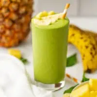 Pineapple banana spinach smoothie topped with pineapple.