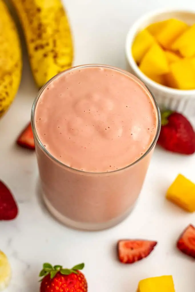Strawberry mango banana smoothie in a short glass.