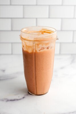 Strawberry mango peach smoothie in a blender cup after being blended.