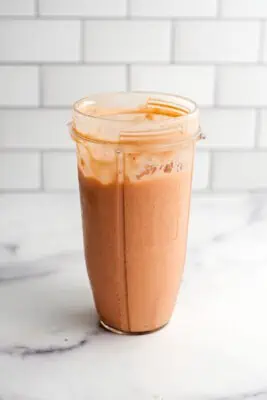 Strawberry mango peach smoothie in a blender cup after being blended.