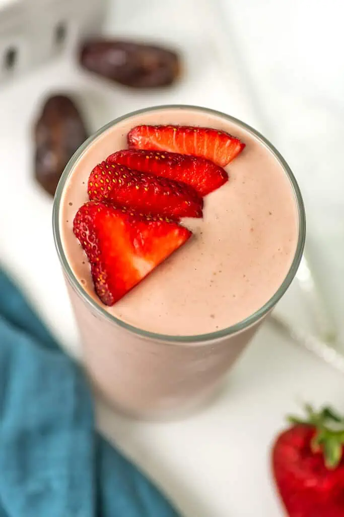 Strawberry smoothie no banana with sliced strawberries on top.