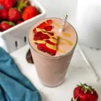 Strawberry tahini smoothie with sliced strawberries.