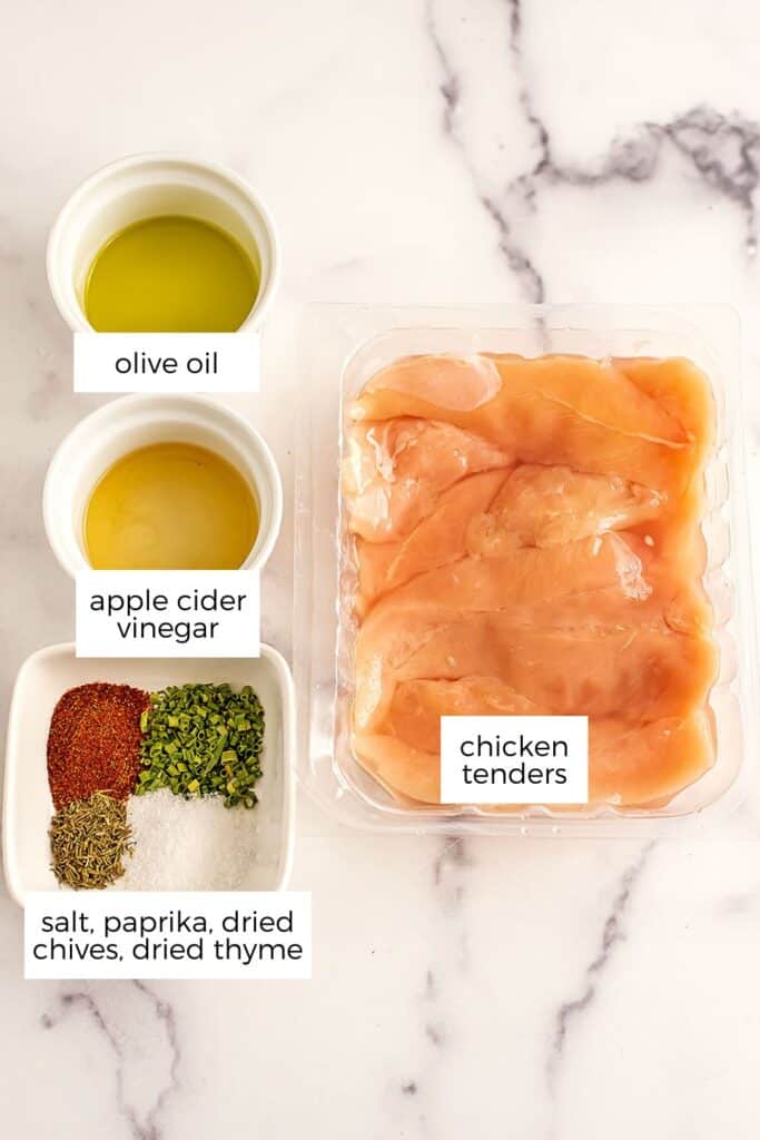 Ingredients to make air fryer grilled chicken tenders on marble countertop.