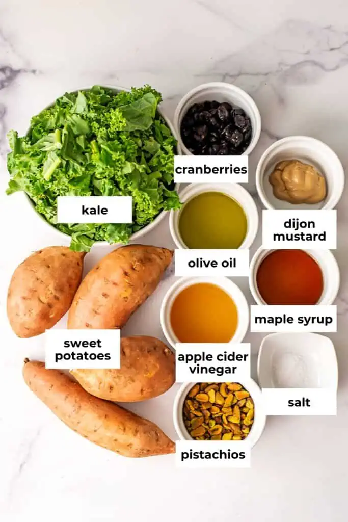 Ingredients to make kale sweet potato salad on marble countertop.