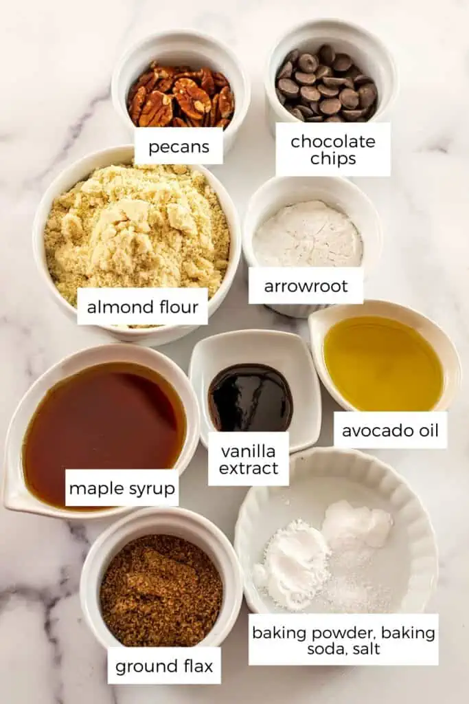 Ingredients to make pecan chocolate chip cookies on a marble countertop.