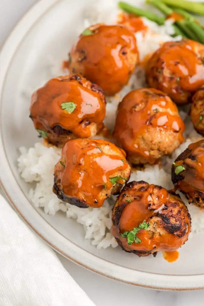 Honey chipotle sauce drizzled over air fry turkey meatballs on a plate.