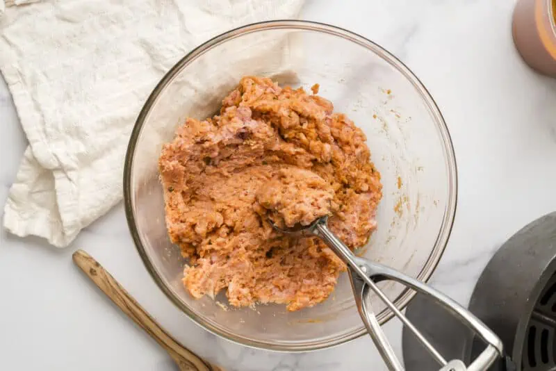 Ground turkey meatball mixture in glass bowl after mixing.